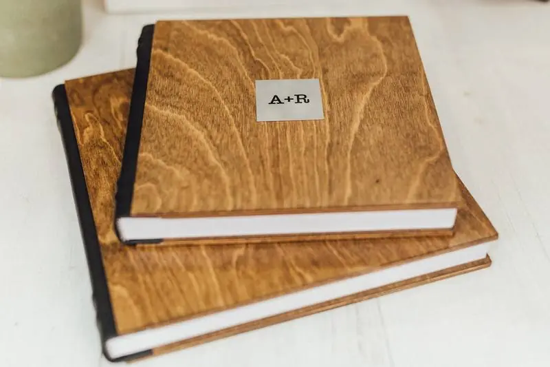 Two copies of the same wedding album with a wooden cover