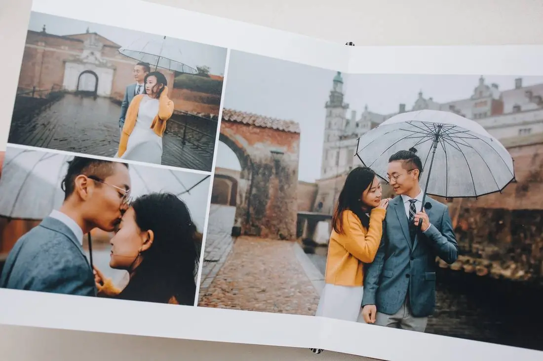 A couple under an umbrella by a castle, across one spread